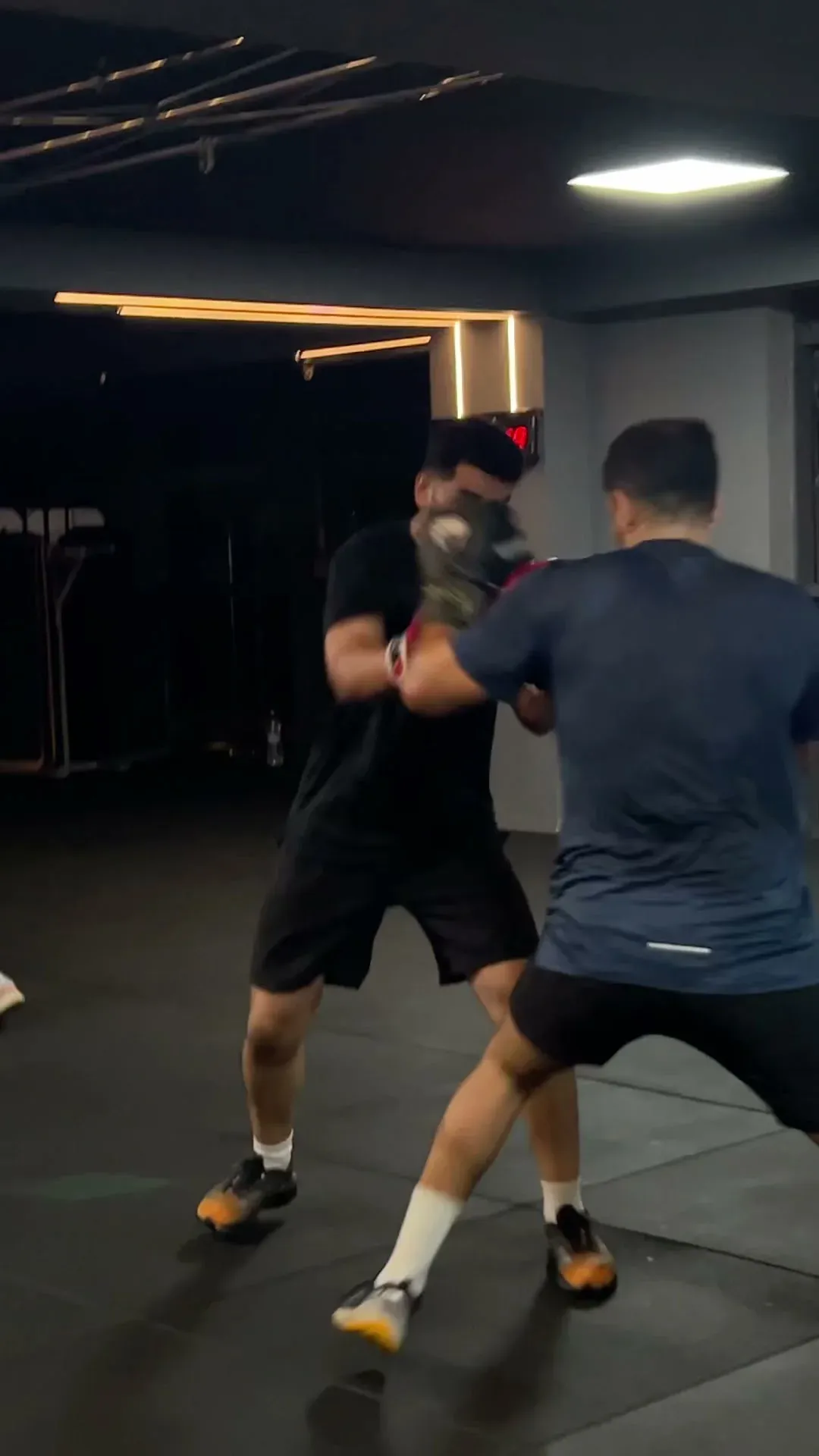Deux adhérents s'entraînent à la boxe avec gants et pattes d'ours