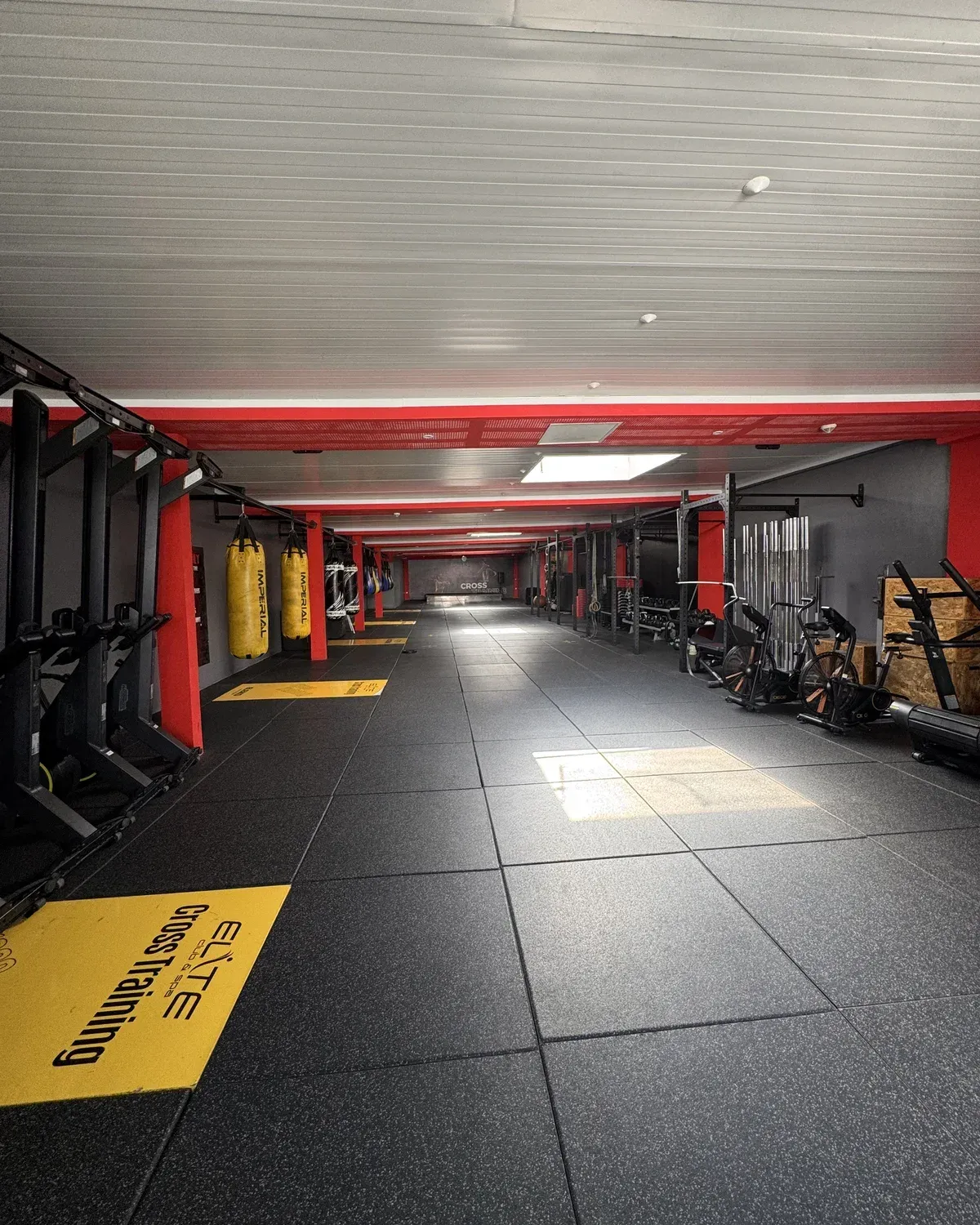 Salle Cross Training d’Elite Club : grand plateau, cages, tapis jaune Elite Cross Training et sol noir