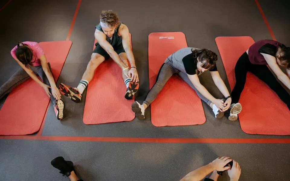 Un groupe s’étire sur des tapis rouges, vu du dessus