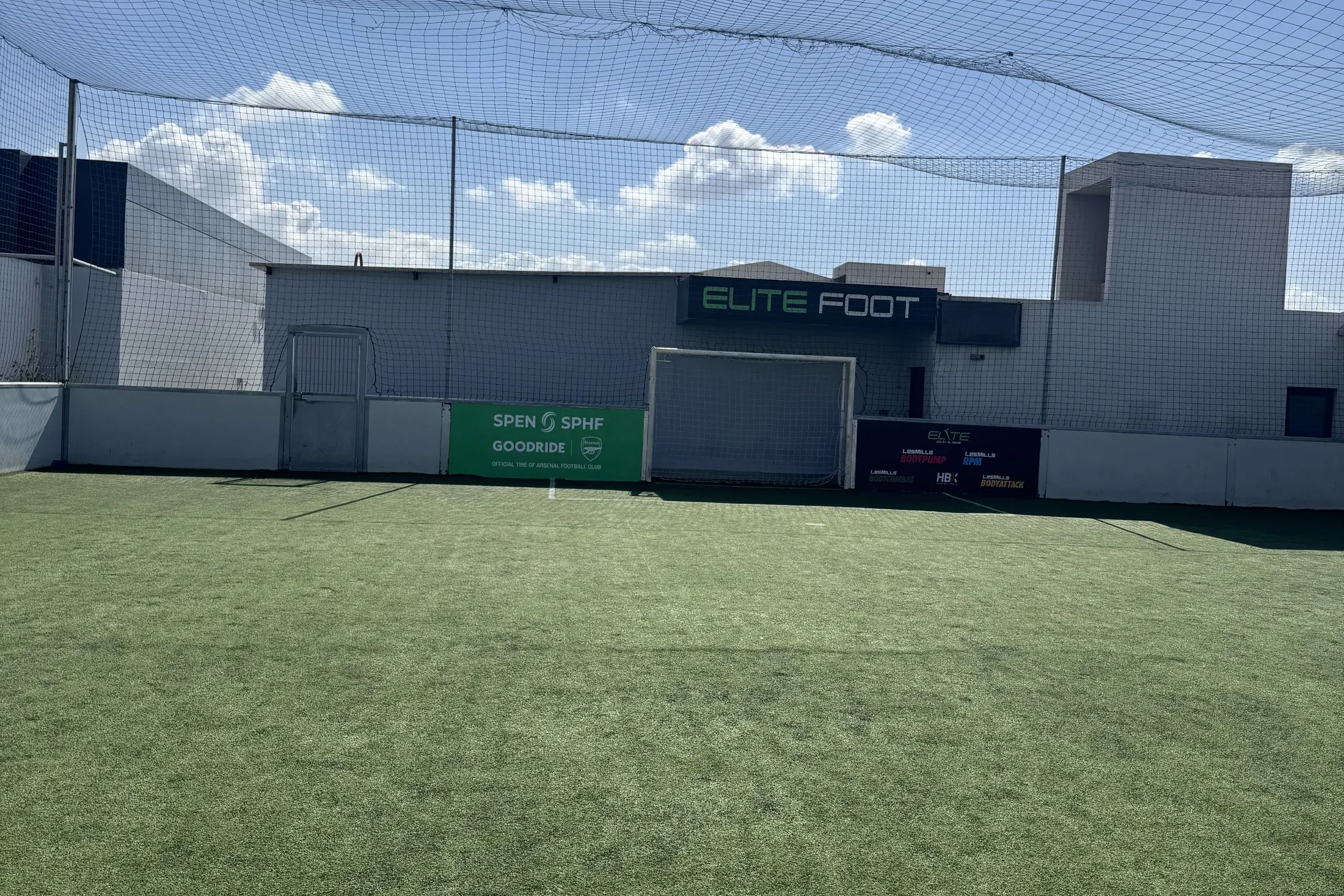 Terrain de mini-foot synthétique sous filet, avec l’enseigne Elite Foot