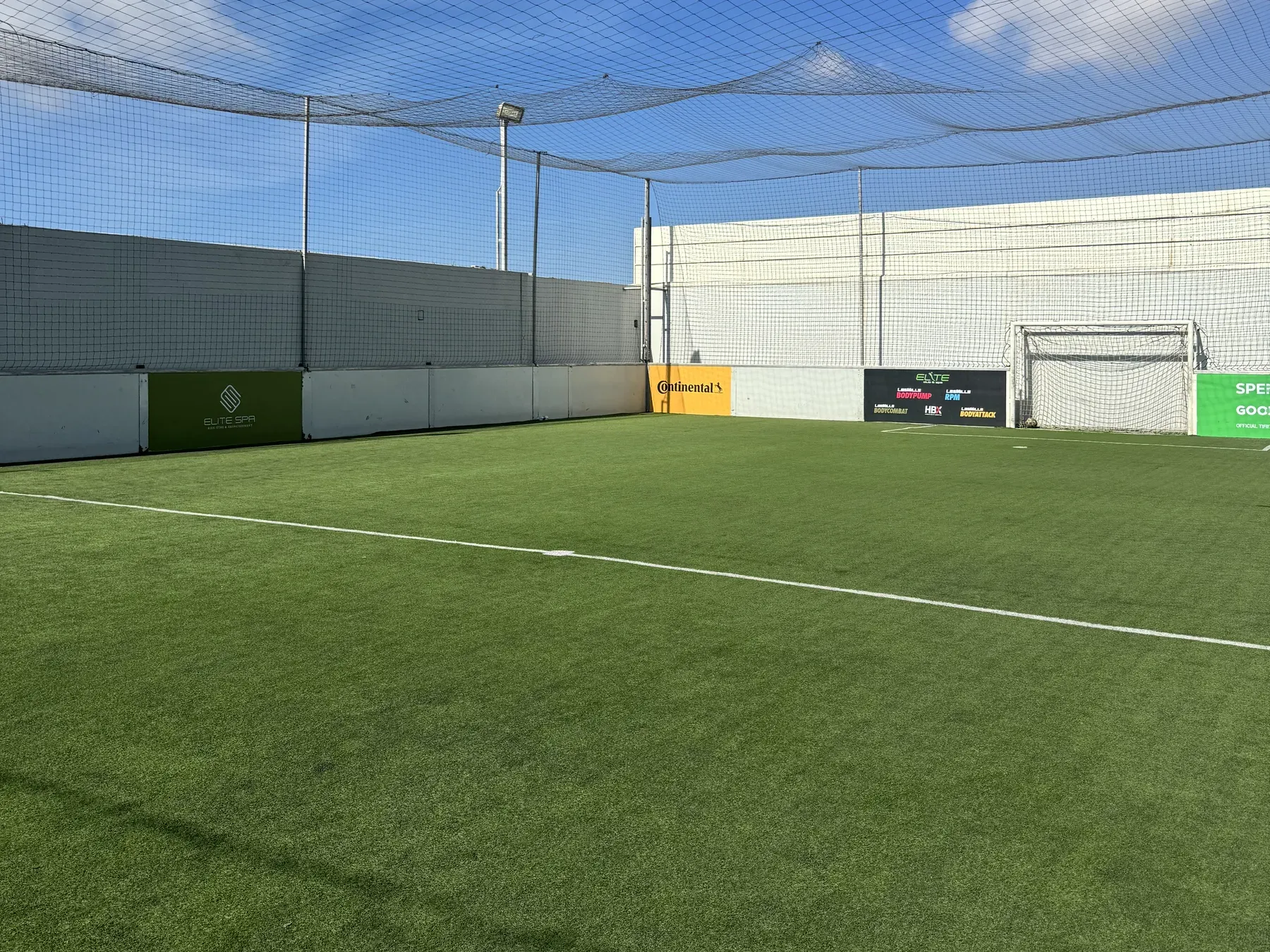 Terrain de mini-foot synthétique sous un ciel bleu