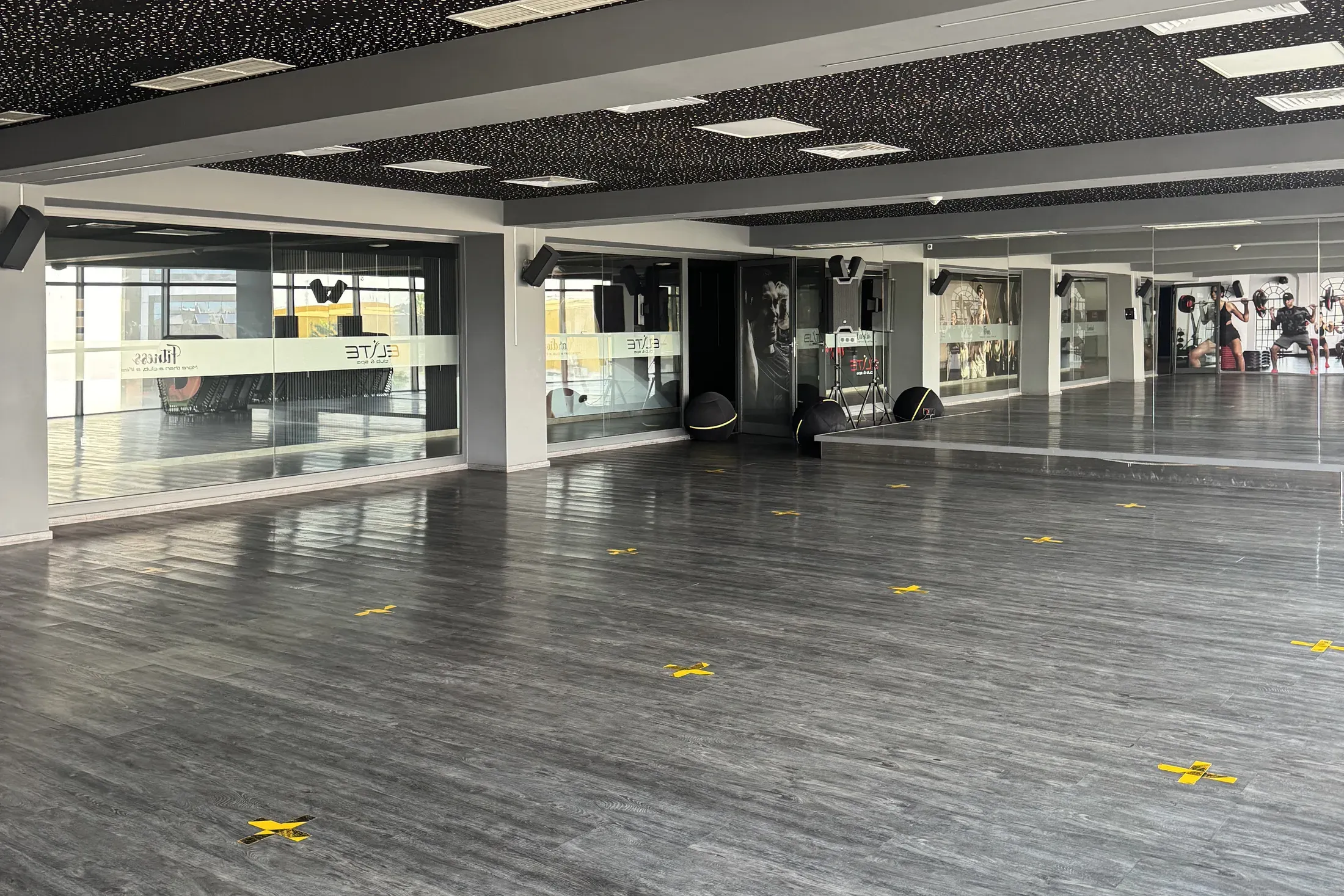 Elite Studio : grande salle de cours au sol sombre, face aux miroirs
