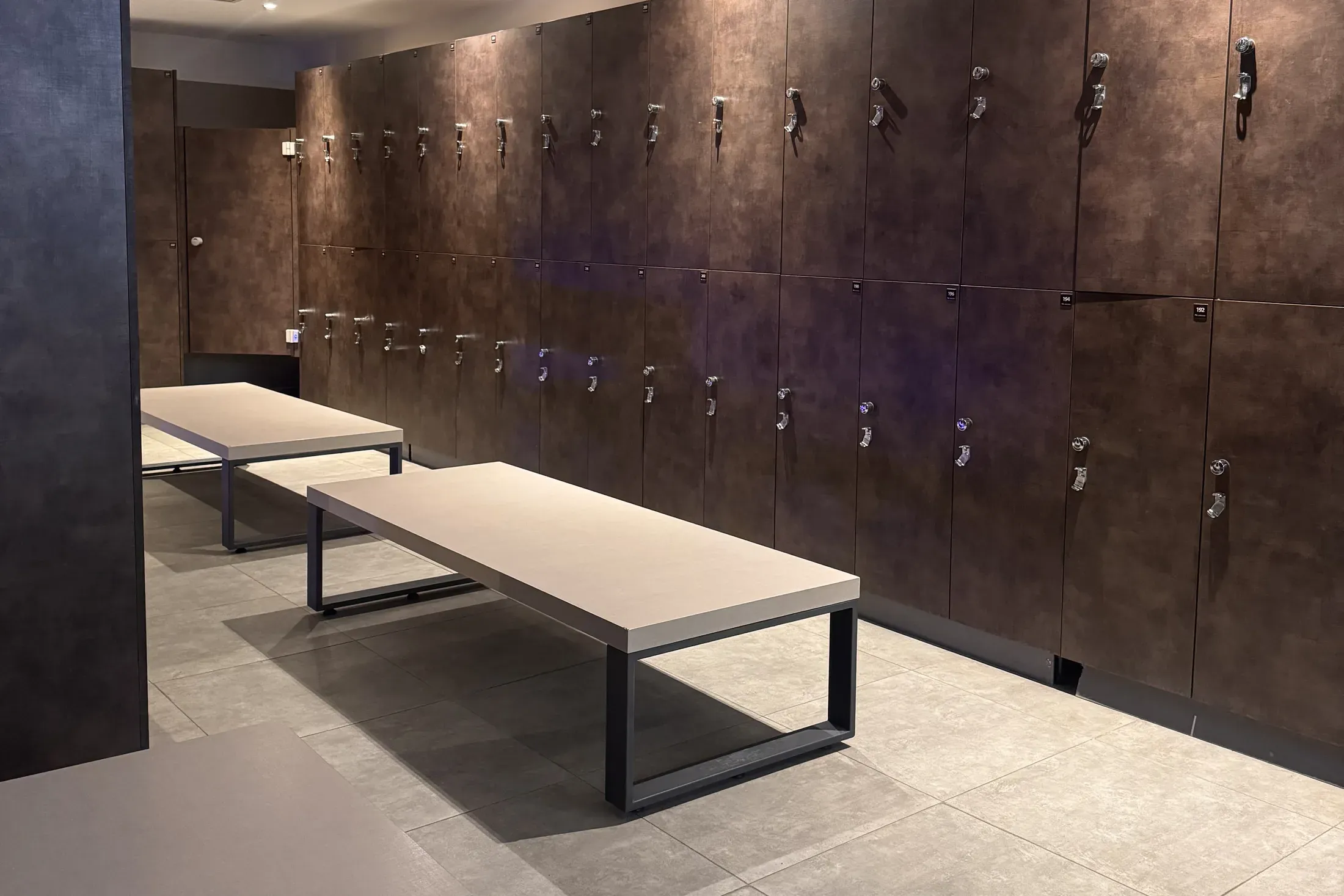 Vestiaires : casiers bruns et longs bancs clairs